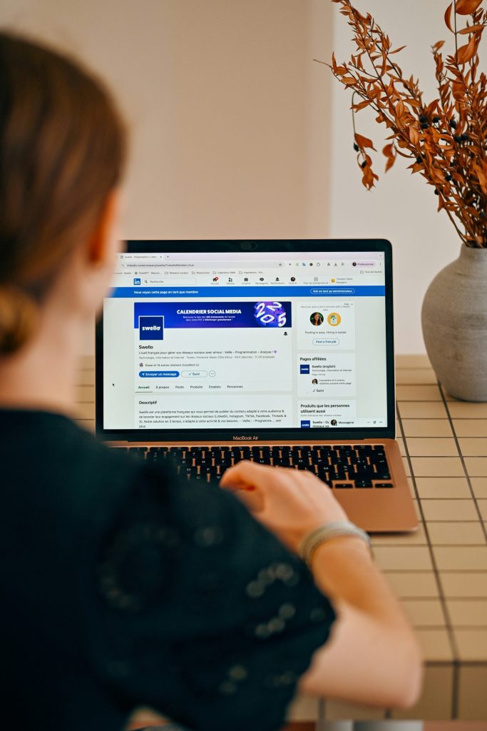 Woman using a laptop with social media open.